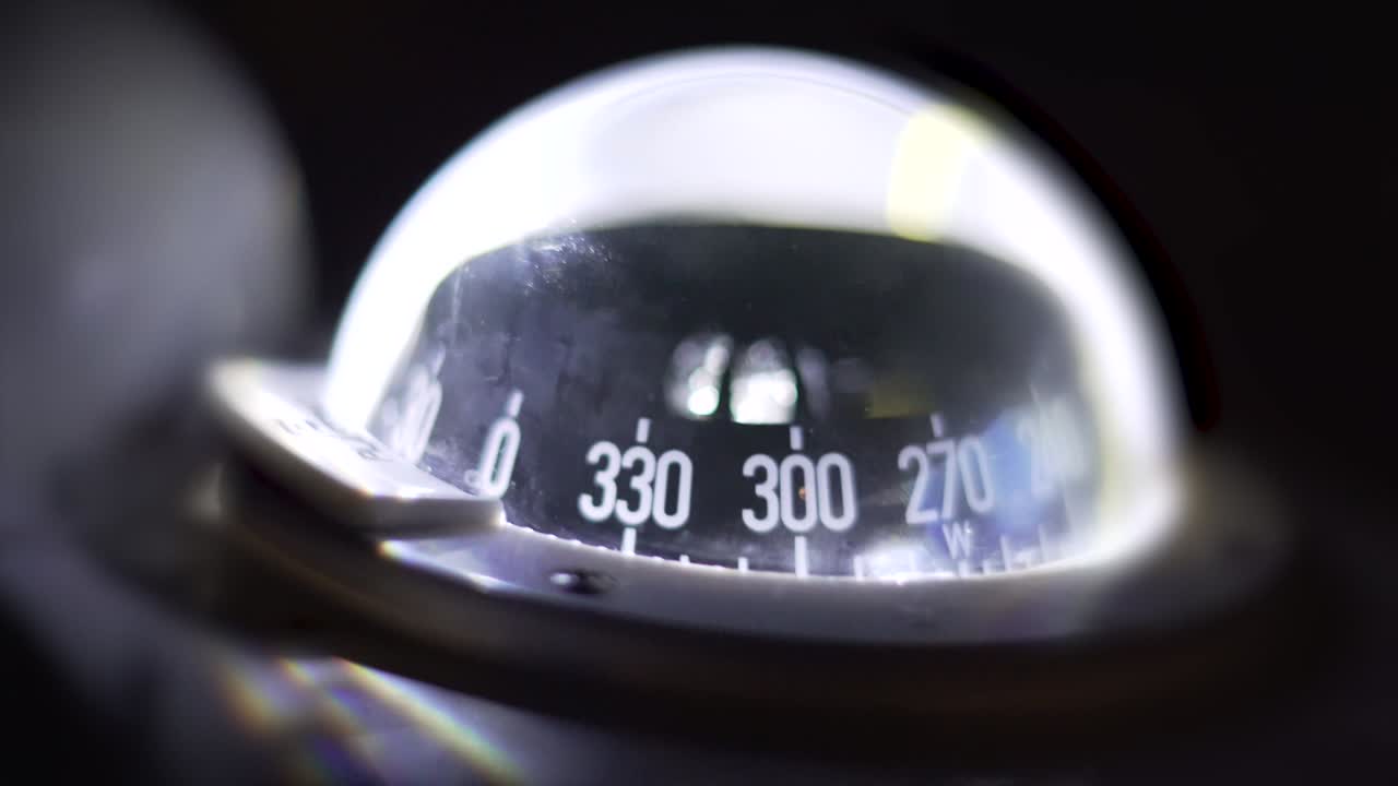 Marine compass on a sailing yacht at night. Backlit compass