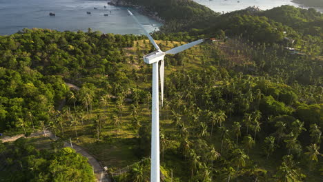 Toma-Aérea-Inclinada-Hacia-Abajo-De-Una-Turbina-Eólica-Parada-En-Koh-Tao,-Tailandia,-Al-Atardecer-Dorado