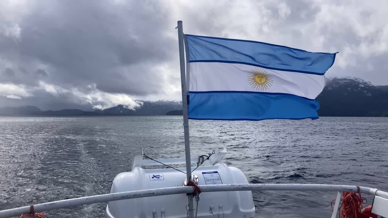 Argentine flag waving on ferry in Nahuel Huapi lake, Villa La Angostura, wide shot