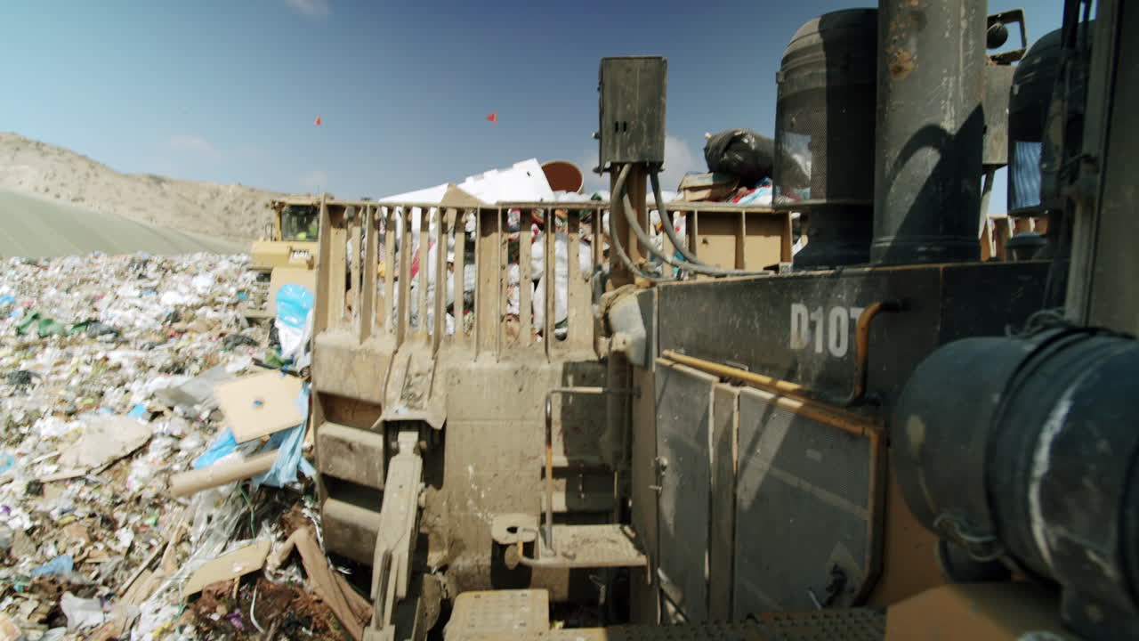 Heavy machinery compacting waste at a large landfill