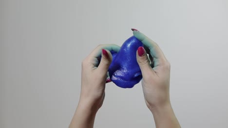 woman hands playing with oddly satisfying blue slime gooey substance. antistress