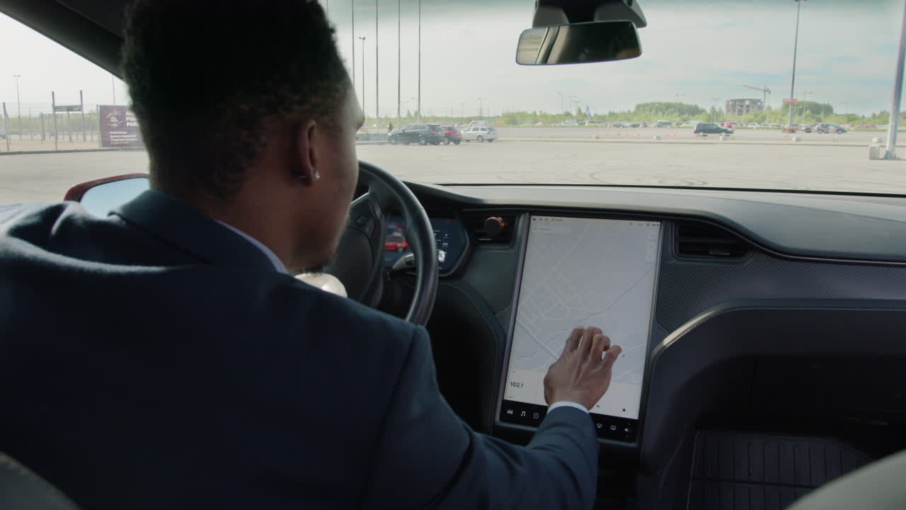 hombre conduciendo un coche eléctrico y usando el sistema de navegación