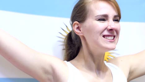 una joven argentina celebra sosteniendo la bandera de argentina en cámara lenta