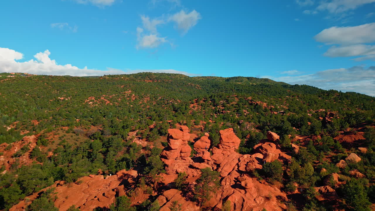 Person stands on the red rounded rock of bentonite clay. Drone footage over the beautiful scenery of Bentonite Hills in Capitol Reef National Park, Utah, United States