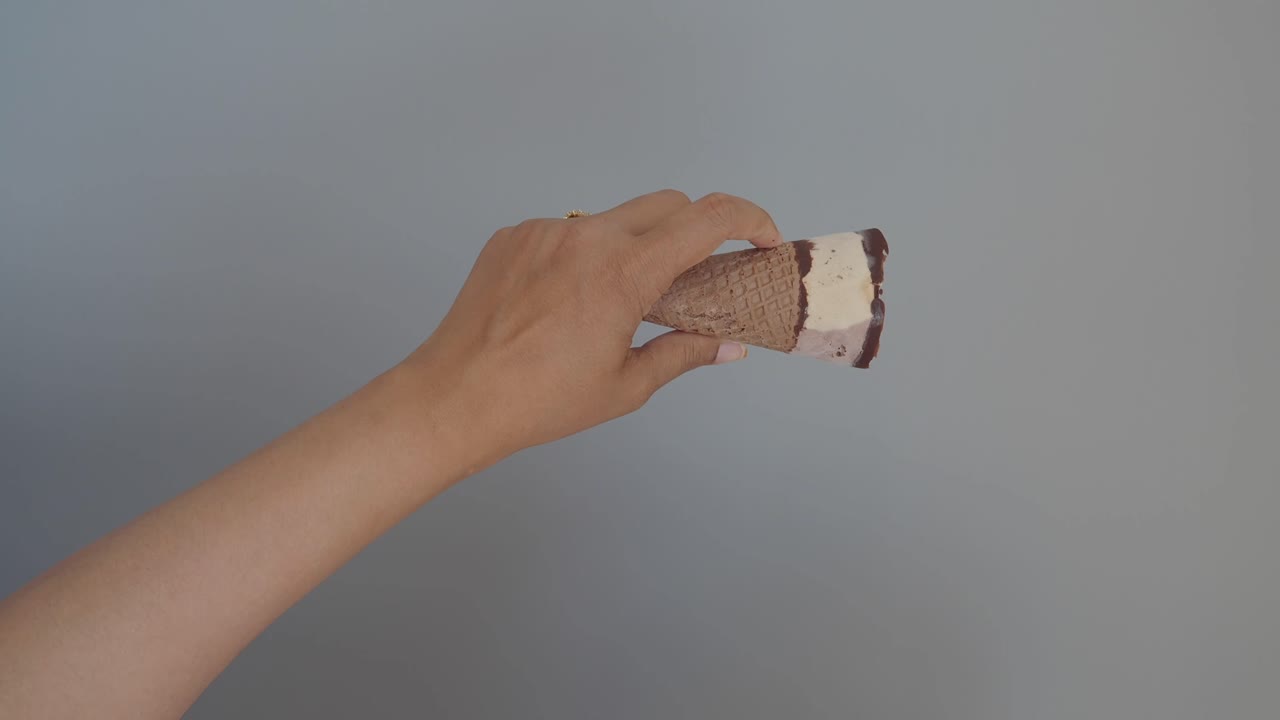 una mano sosteniendo un cono de helado