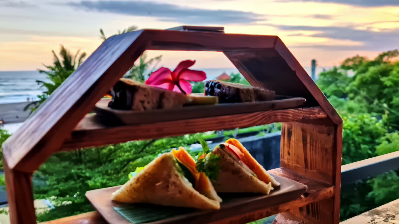 Wooden tiered tray with cakes and sandwiches, served at a café in Pantai Berawa, Bali