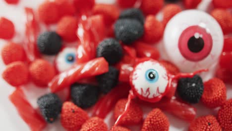 vista de cerca de la variedad de dulces de halloween caídos contra un fondo gris