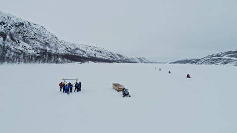 Motos-De-Nieve-Se-Dirigen-Al-Agujero-De-Hielo-Para-Un-Safari-De-Cangrejo-Real-En-Noruega---Vista-Aérea