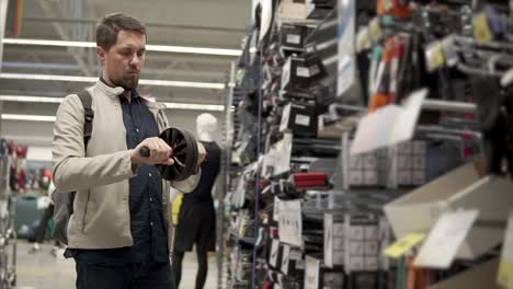 man inspecting a wheel in a hardware store