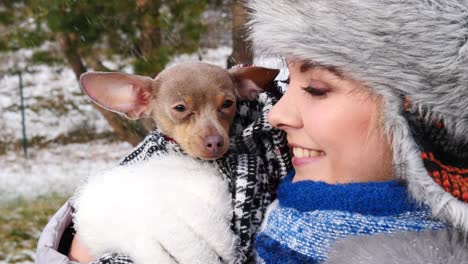 woman playing with her little dog outside winter