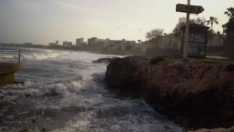 ocean waves crashing onto shore on mallorca during the late evening sun