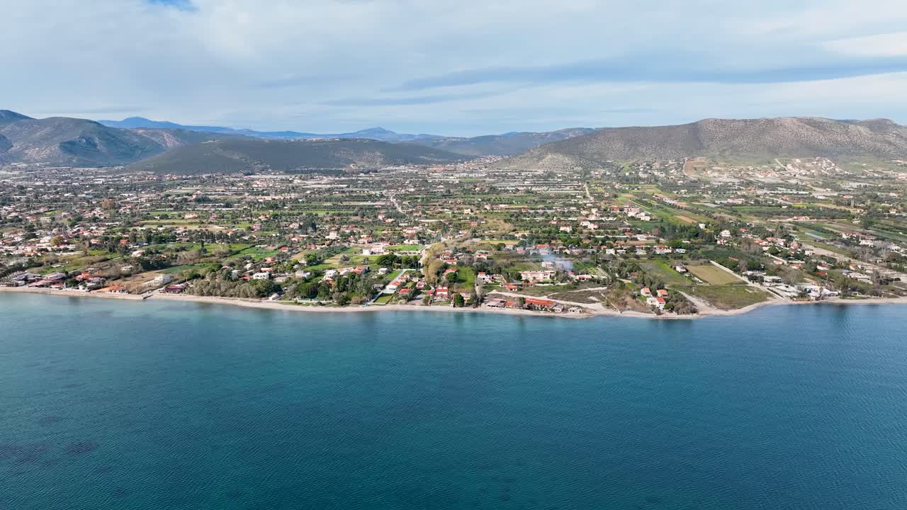 집과 농경지가 있는 해안선을 향해 날아가고 있습니다.