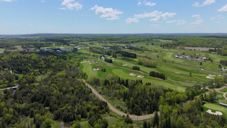 aerial flyover of tpc toronto at osprey valley golf course and surrounding forest in ontario, canada.