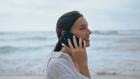 Frau-Telefoniert-Am-Bewölkten-Strand,-Nahaufnahme.-Mädchen-Geht-In-Der-Nähe-Von-Meereswellen-Spazieren.