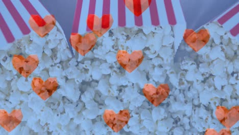 animación de iconos de corazón sobre cajas de palomitas de maíz