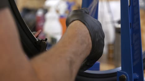 close up of male bike mechanic straightening a bike wheel