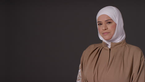 Studioporträt-Einer-Muslimischen-Frau-Mit-Hijab-Vor-Schlichtem,-Dunklem-Hintergrund-1