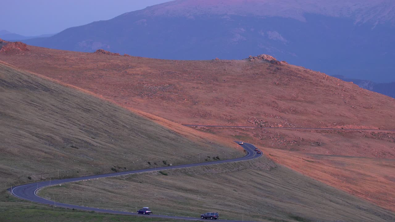 석양에 록키 마운틴 국립 공원에서 운전하는 자동차