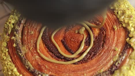 pistachio donut being decorated filling top view