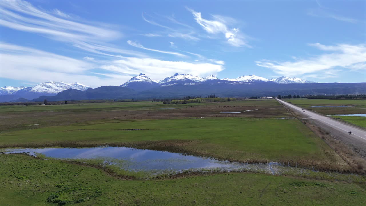 un viaje impresionante a través de chubut y trevelin, argentina, mostrando paisajes impresionantes con montañas cubiertas de nieve como telón de fondo, ofreciendo una vista pintoresca de la región patagónica.