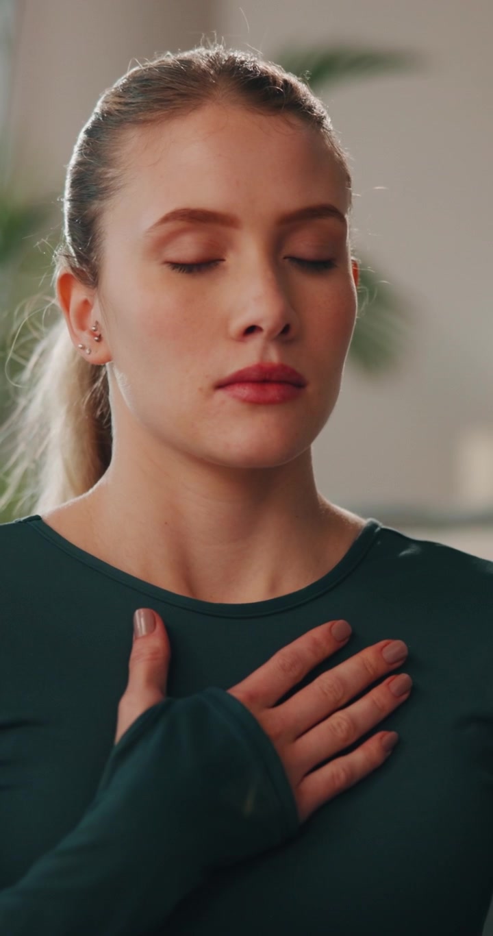 Giovane donna che pratica respirazione consapevole e meditazione
