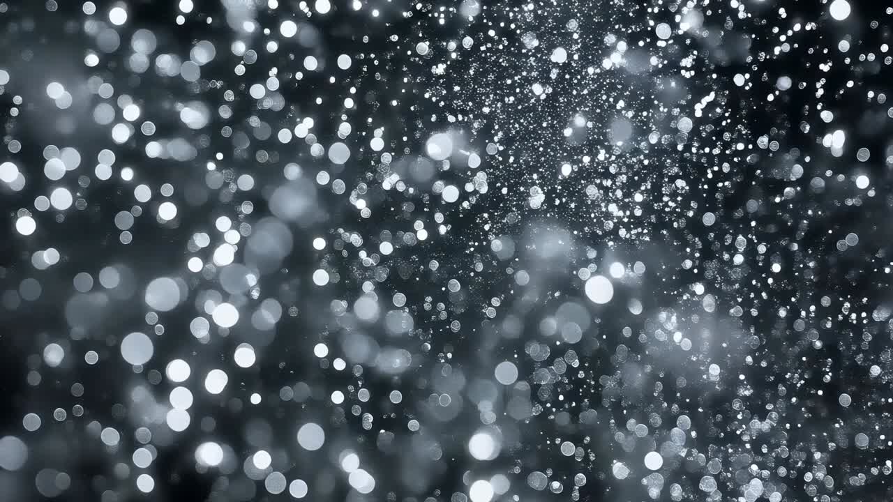 Particelle luminose che fluttuano dopo un impulso di luce in un primo piano in studio buio, che mostrano un flusso bokeh