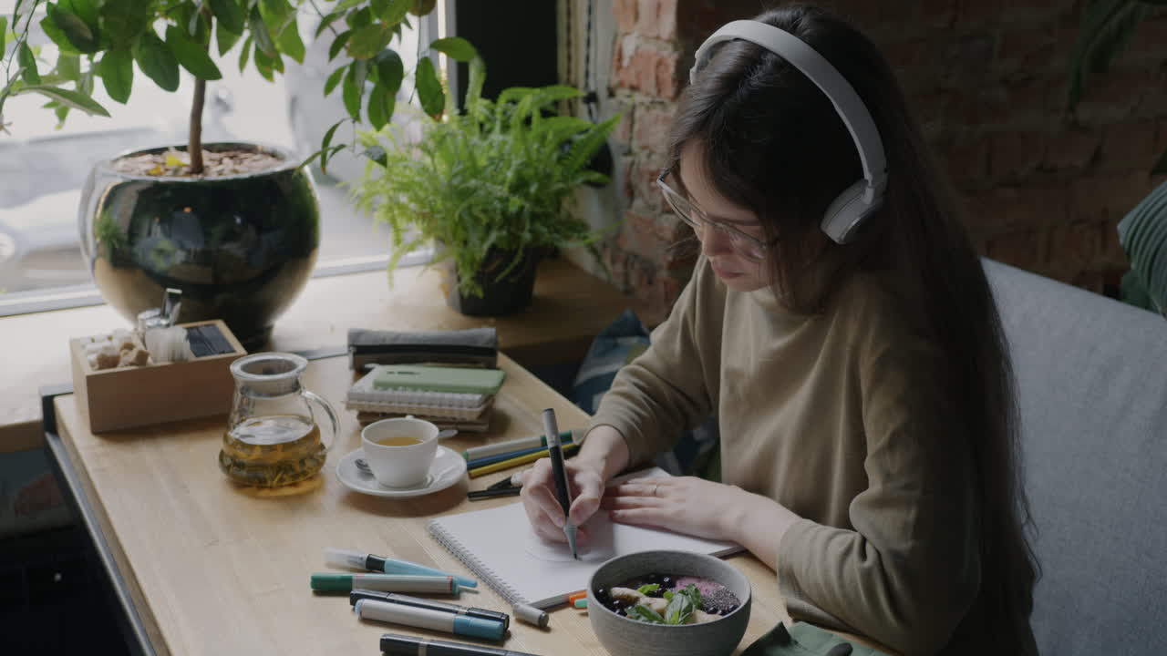 Woman Drawing in a Cafe