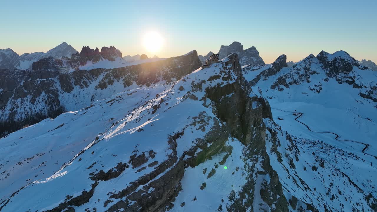 Hütte auf einem Felsen in den Dolomiten bei Sonnenaufgang im Winter