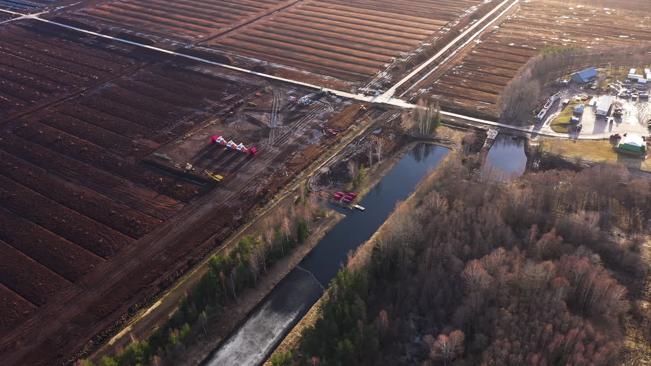 gran campo de recolección de turba con maquinaria pesada en vista aérea