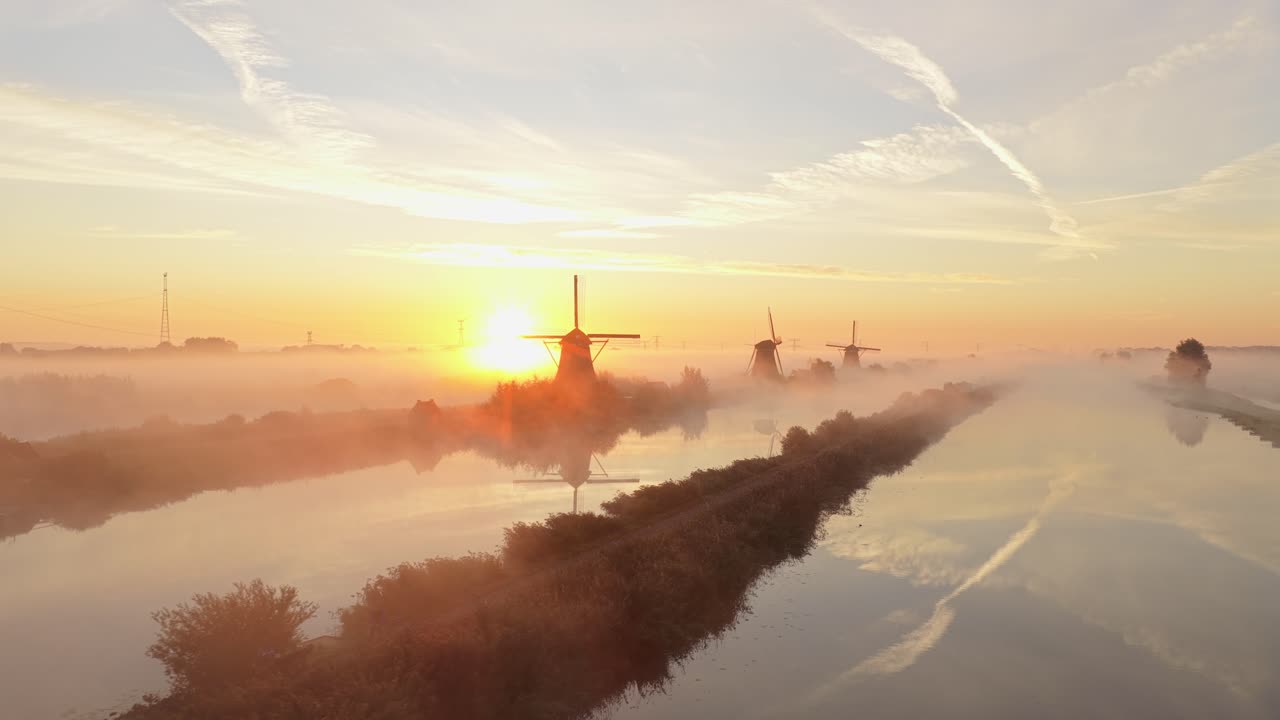 Schilderachtig panorama van de Kinderdijkse molens in gouden zonsopgangmist, Holland