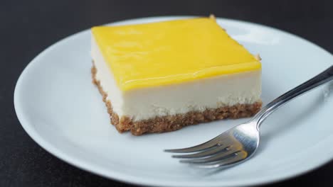 una rebanada de pastel de queso de limón en un plato