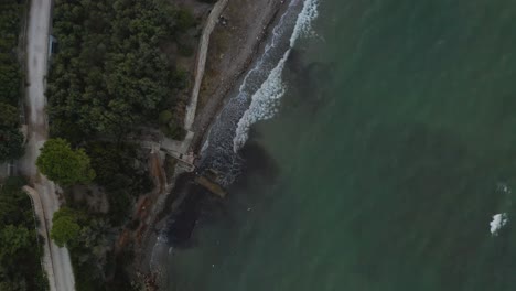 Drone-aerial-birdseye-view-of-a-beach-side-dirt-road