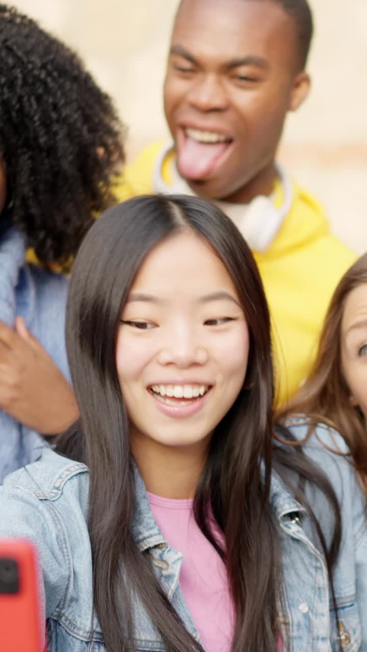Chinese girl taking a selfie with diverse friends outdoors