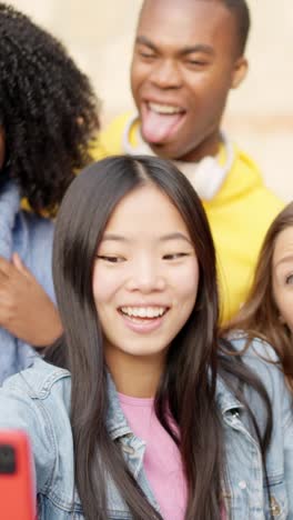 chinese girl taking a selfie with diverse friends outdoors