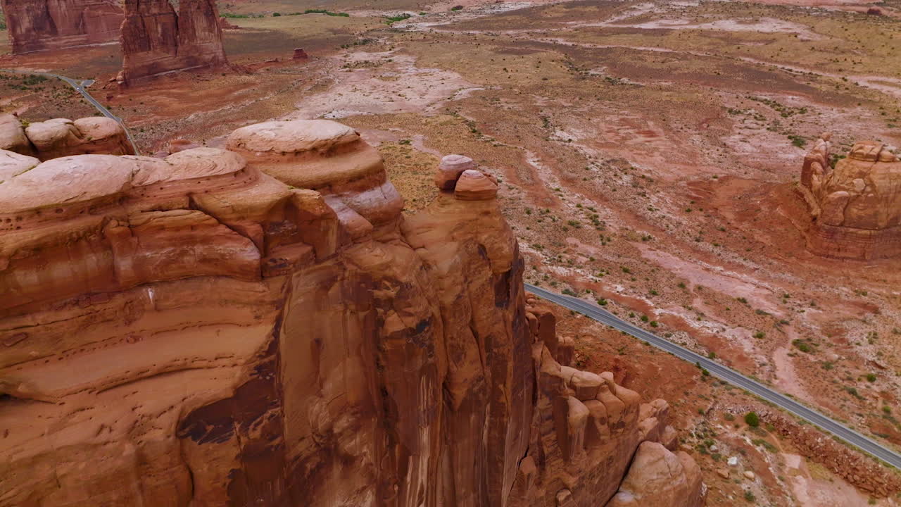 Flying over the canyon and plain in the national park of America. Speed highway going along the flat among the beautiful rocks. Top view.