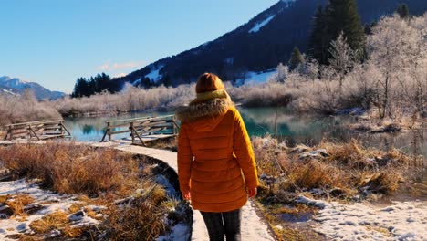 4k video of a young caucasian female walking on a path in the natural reserve - zelenci, slovenia