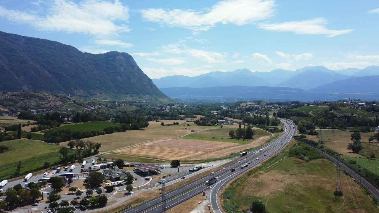 Aerial view of a highway through a valley with mountains