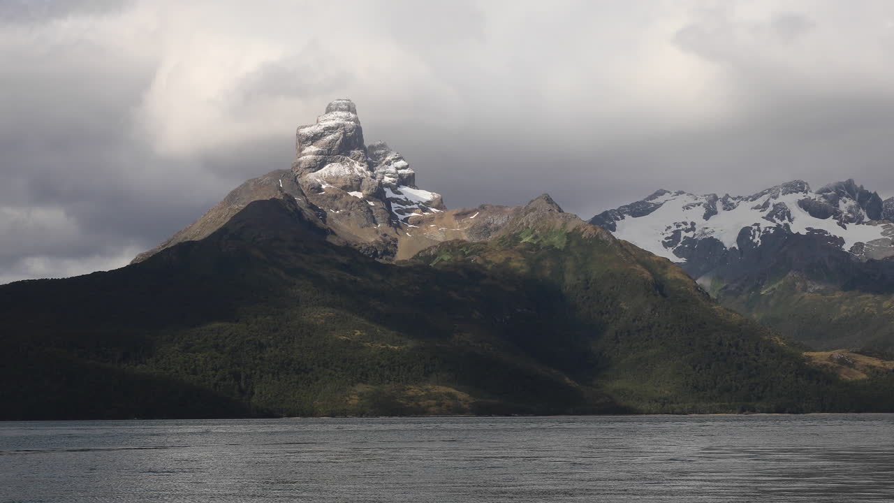 무거운 구름이 파타고니아 피오르드에 있는 다윈 산맥을  ⁇ 고 있습니다. 칠레, 칠레, 남아메리카
