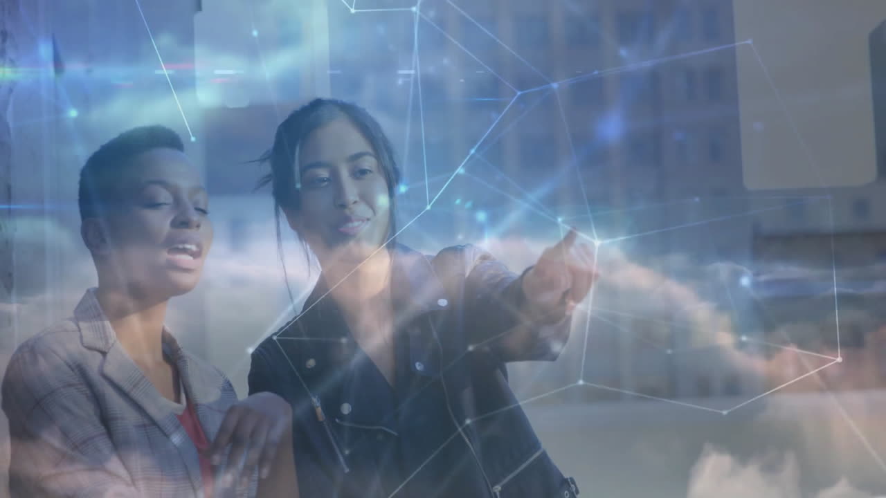 Two women colleagues analyzing technology network display by office window, featuring cloud nodes