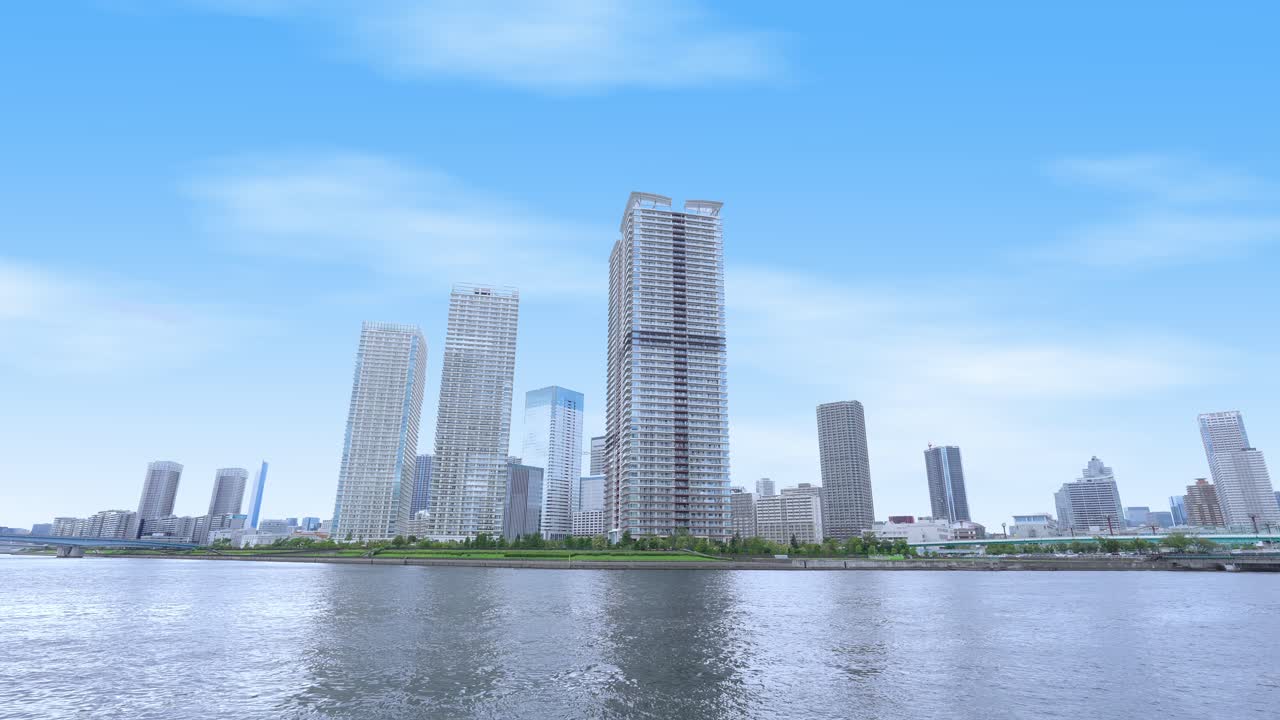 A peaceful wide shot of the Tokyo skyline from a waterfront promenade with modern high-rise buildings and a clear sky