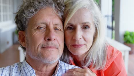 Senior-couple-looking-at-camera-on-the-porch-at-home-4k