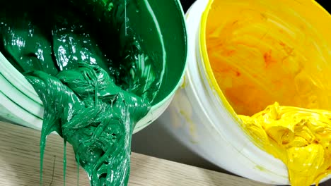 green yellow and red colors of plastisol ink in white plastic cans