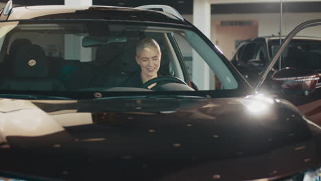 mujer probando un coche nuevo en una sala de exhibición