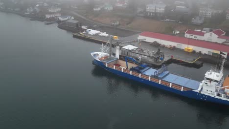 Hiperlapso-De-Descarga-De-Pescado-De-Un-Carguero-En-Faskrudsfjordur,-Este-De-Islandia---Drone-Aéreo