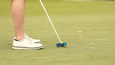 a golfer stepping up to a put and making it on a golf course