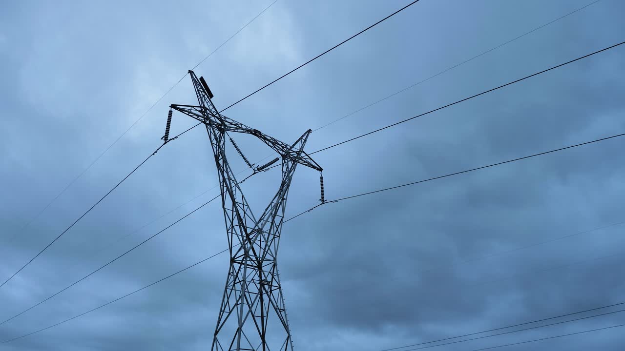 Low wide view of high voltage power lines on a cloudy overcast day