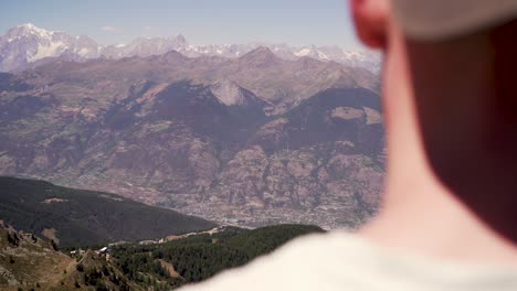joven con una gorra con vistas a la hermosa ciudad montañosa de aosta