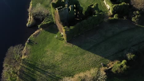 aerial top-down tracking shot along the river shore leading to menlo castle