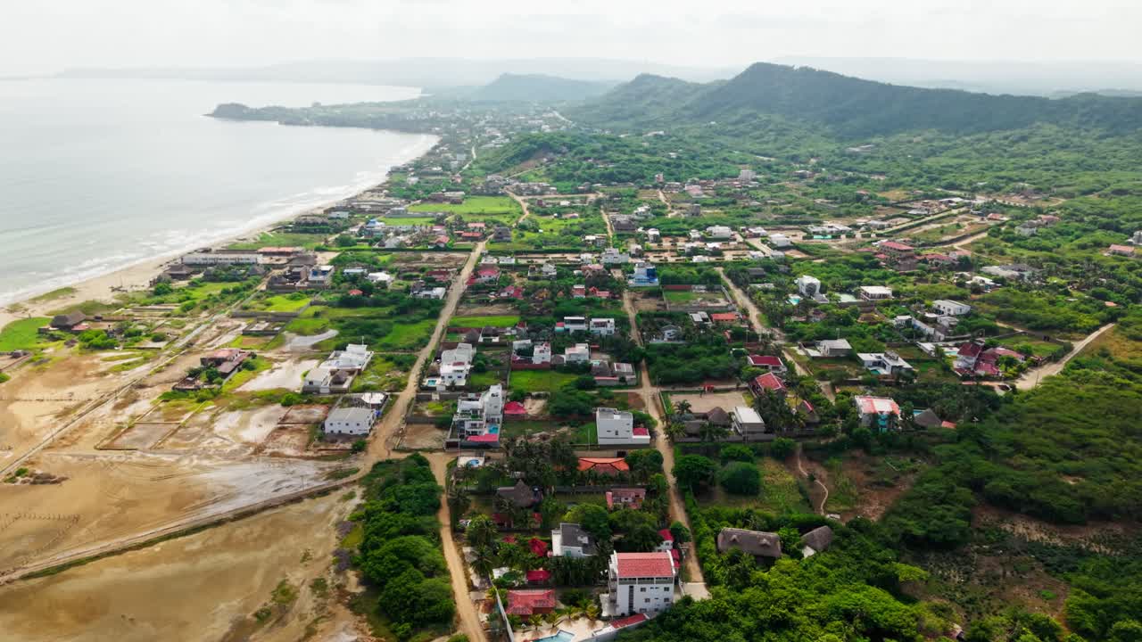 Tranquil coastal town nestled between lush green hills and a serene ocean, captured in a slow-motion aerial view, salinas del rey, colombia