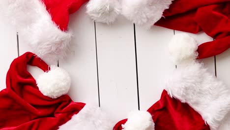 Santa-Claus-hats-on-white-wooden-desk-with-blank-copy-space-